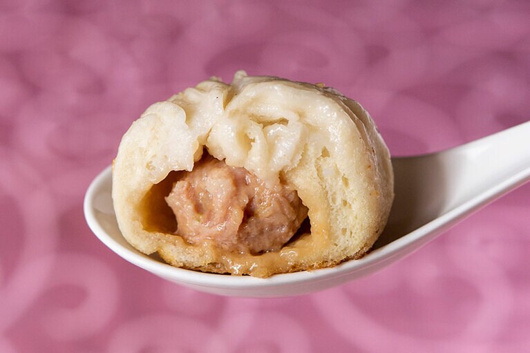 ［高記 永康店］鉄鍋で蒸し焼きにした焼き小籠包。油で焼いてから蒸すので、表面はカリッと香ばしく、中は肉まんのようにふかふか。