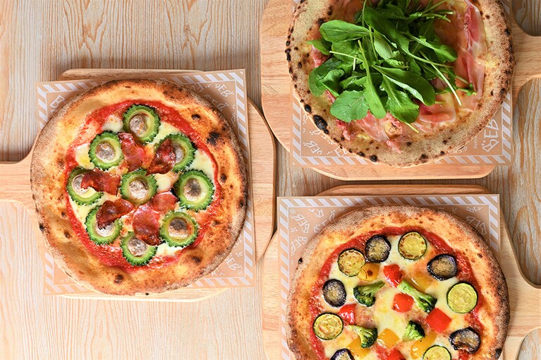 焼きたてのおいしさが評判のピッツァ。左から「ゴーヤサルシッチャ」「生ハムルッコラ」「オルトラーナ」各1,500円。