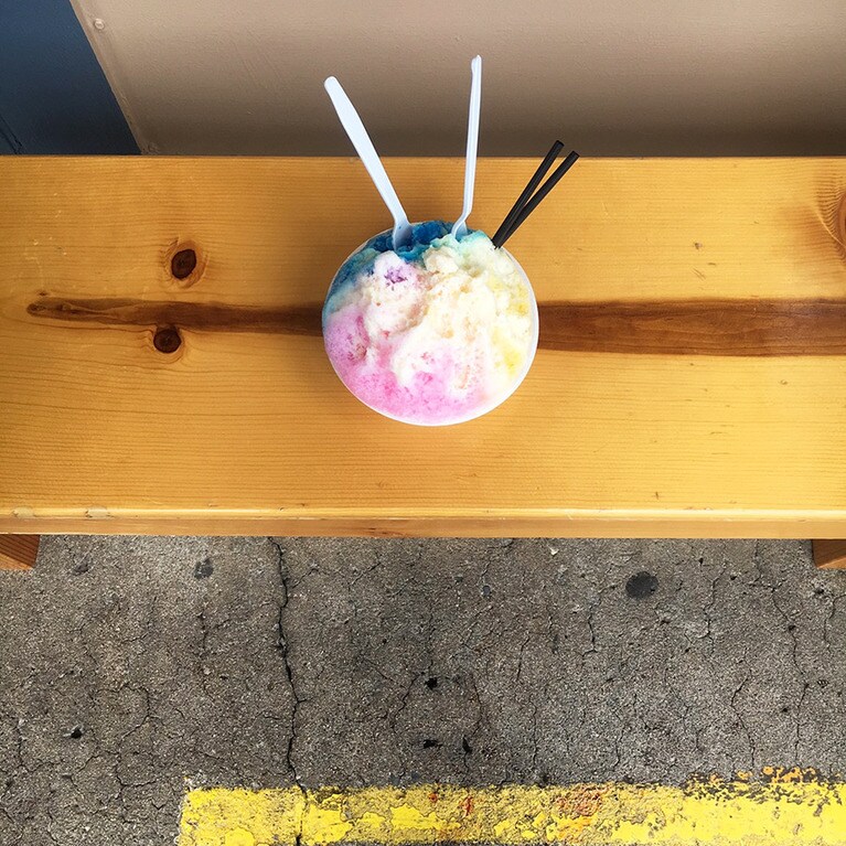 ピンクはライチー、黄色はパイナップル、青色はブルーベリーにコンデンスミルクをかけてモチと小豆も隠れているシェイブアイス。ケイキサイズで7ドル。