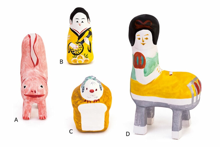 A：1980年代に一世を風靡したあの小動物も張り子に。〈ウーパールーパー〉1,600円。  B：伝統モチーフの張り子も見逃せない。〈三線人形〉1,200円。  C：食パンの上に鳩がちょこん。〈鳩パン〉1,200円。  D：豊永さんの手により、グリム童話の世界が琉球張り子に。〈ベッドから起き上がる白雪姫〉2,700円。