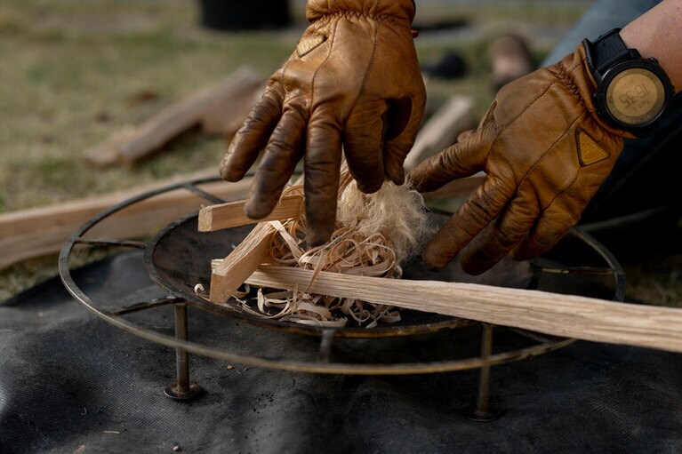 フェザースティックを焚き火台に置き、その上に麻紐を絡ませる。