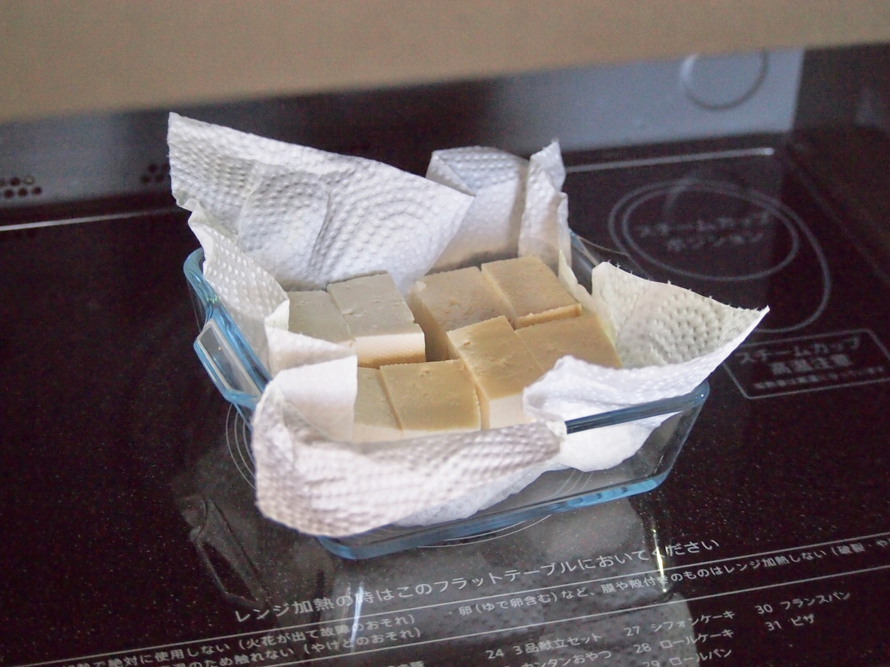 木綿豆腐は、食べやすい大きさに切る。耐熱の器にクッキングペーパーを敷き、豆腐をのせて600wのレンジで2分加熱し、水分を飛ばす。