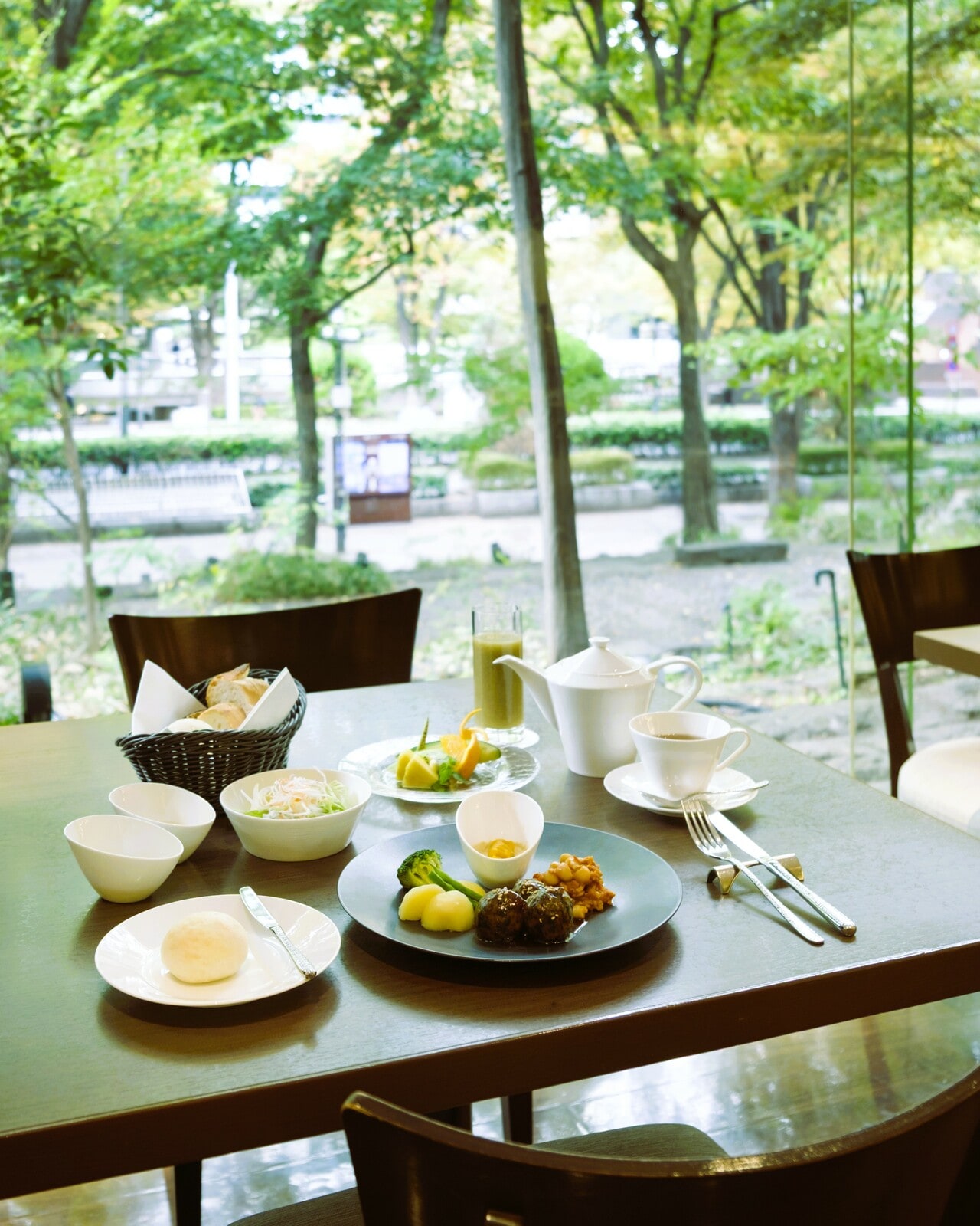 武蔵野の原風景に着想を得た「雑木林庭園」が窓の外に広がるオールデイダイニング「樹林」。造園家・深谷光軌氏が生み出したこの「外空間」は、ホテルといえば伝統的な日本庭園が一般的だった当時、自然との調和というコンセプトを時代に先駆けて取り入れた斬新さで大いに話題を集めました。