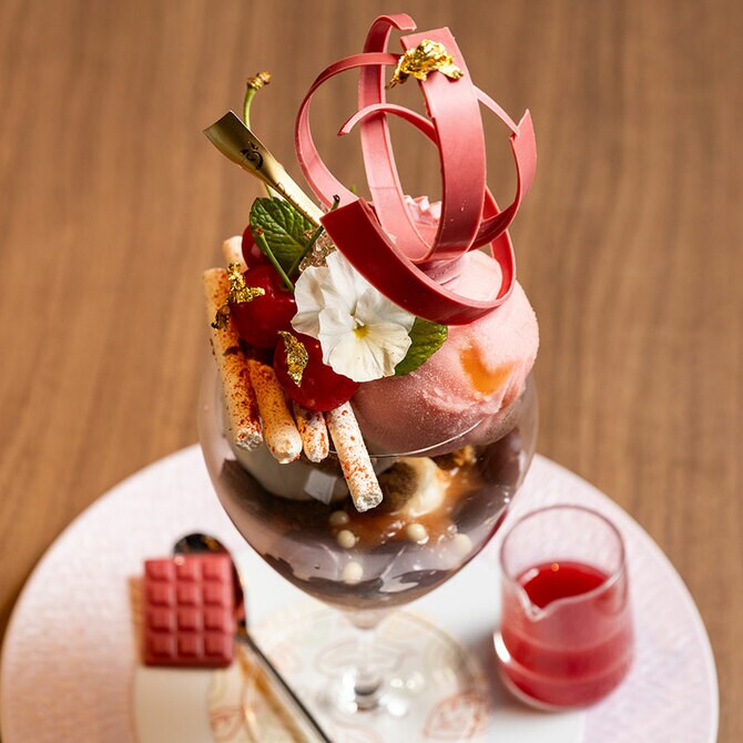 ソースと小さなチョコレートのタブレット添えて。季節替わりのパフェには、パフェへと誘う「はじまりのタブレット」として、必ず小さな板チョコレートを添える。