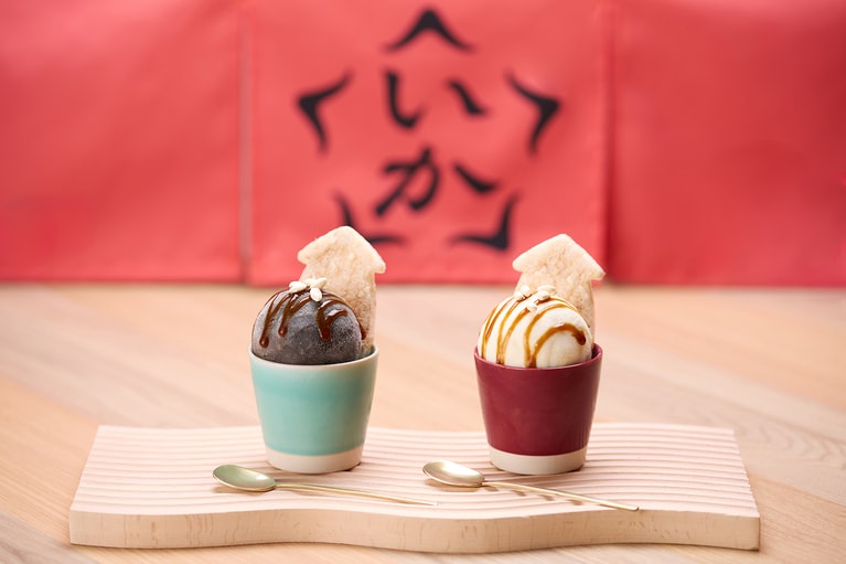 （左）いかすみの風味が特徴の「いかめしアイス〈いかすみ(カン)〉」 、（右）キャラメルソースが映える通常の「いかめしアイス」。