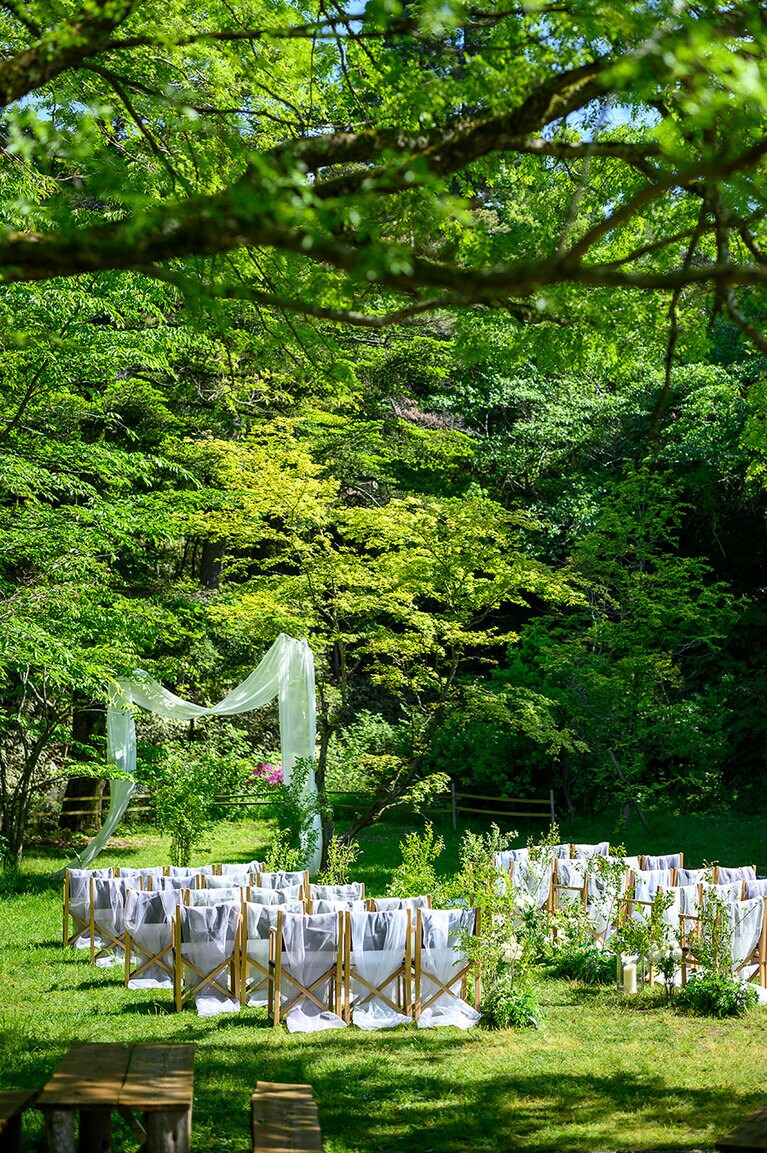 ベールでアーチが作られ、白い参列席がまぶしい！　森の挙式会場で至福の瞬間を。