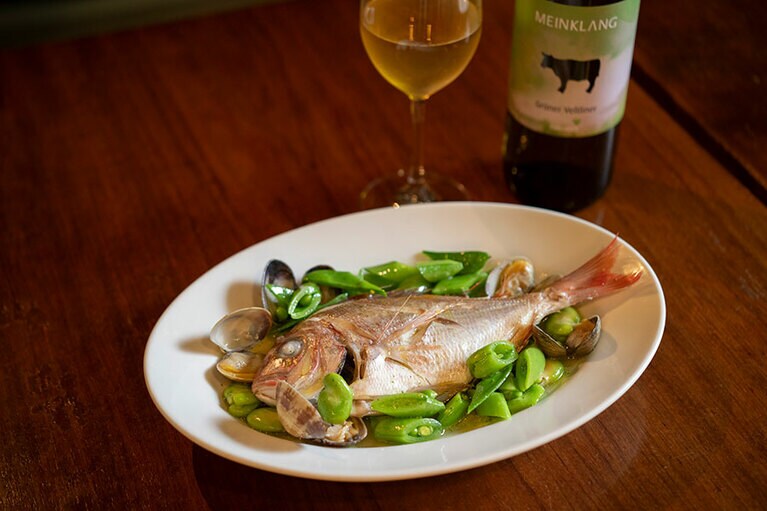 「三崎の真鯛の蒸し物 アサリと季節の豆のソース」2,500円。オーストリアの白ワインと。