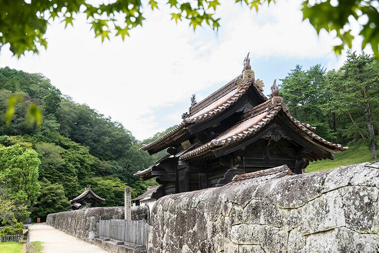 石塀は全国的にも珍しい、上部や端が丸いかまぼこ型。ノミを使いすべて手加工で仕上げられたそう。