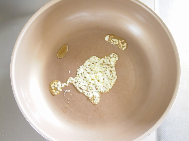フライパンに（1）のにんにく、オリーブオイルを入れて加熱する。