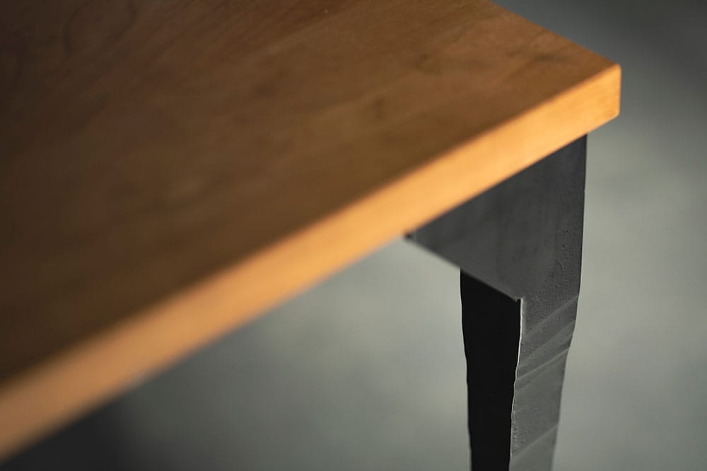 同じくTAonTAの自由鍛造による脚付きのテーブル。脚は1,200℃以上に熱した鋼材を職人がひとつずハンマーで叩き造形している。220,000円～。