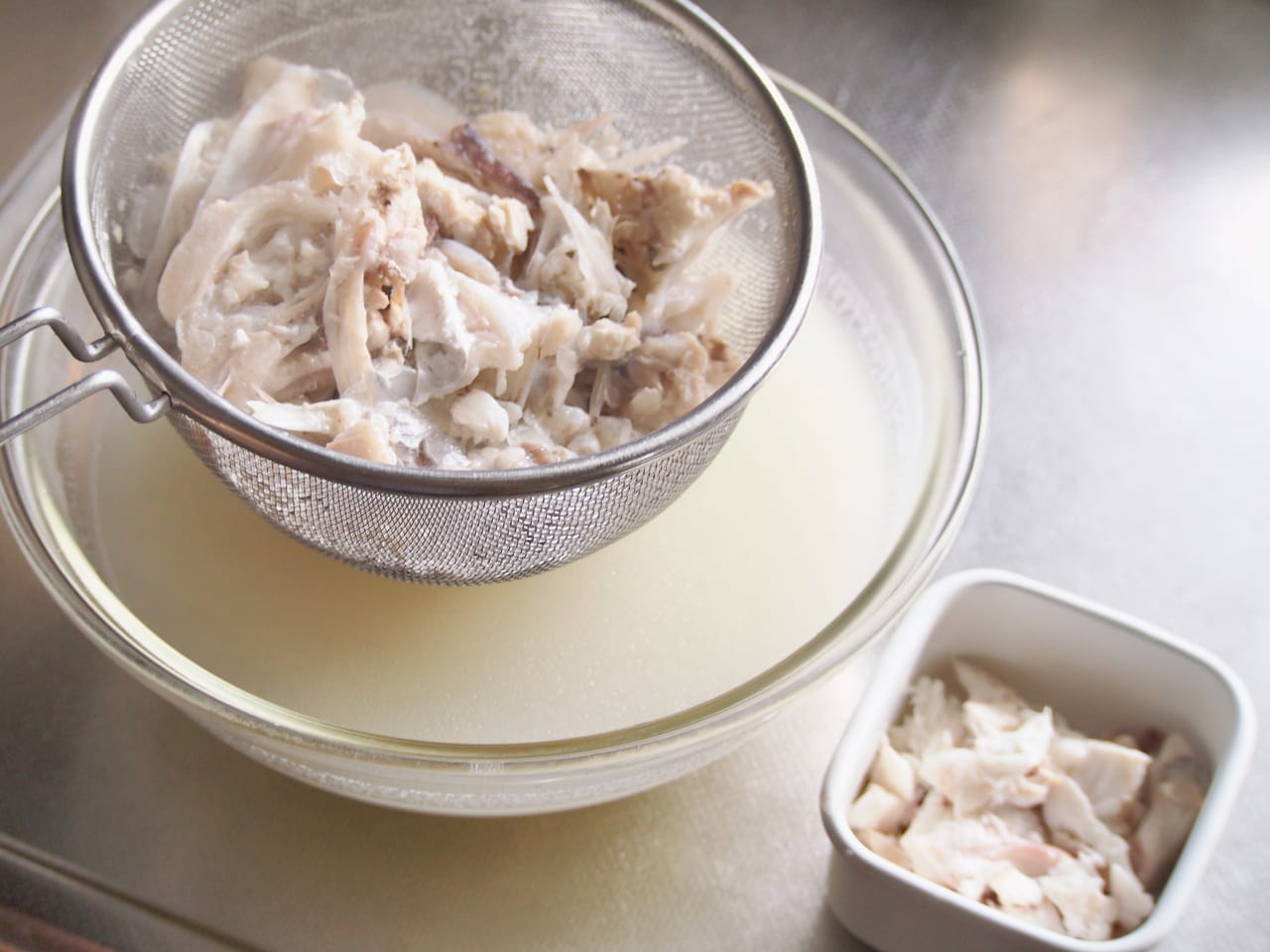 スープが白濁してきたらアラをザルで漉す。身の部分は取り出すのがおすすめ。