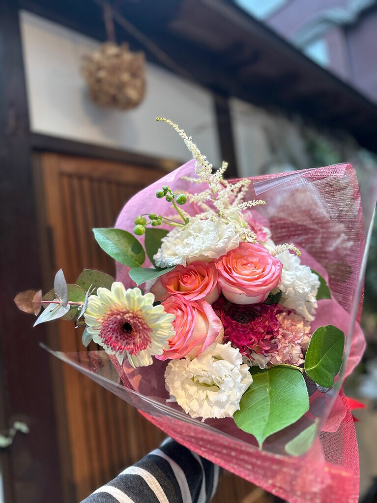 バラ、カーネーション、リシアンサス、ガーベラのバリエーションに富んだ花束。