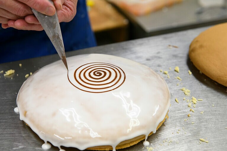 チョコレートで渦巻き状にアイシングし、特殊加工のフォークで中央から放射状に手早く模様を描きます。