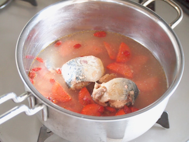 手鍋に水、人参、クコの実、鯖缶を汁ごと入れ、火をつける。