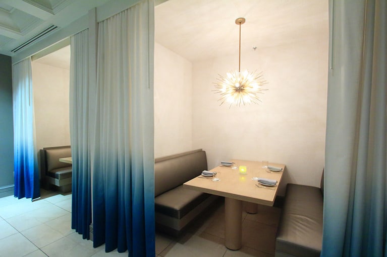 海をイメージさせる白とブルーのカーテンで仕切る個室。