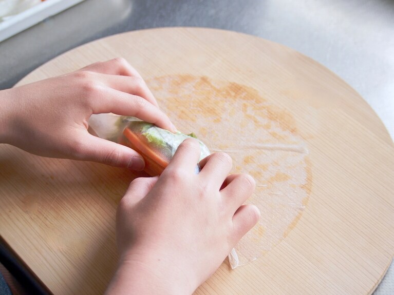 キュッと締めるように皮を巻く。両サイドを折り畳み、奥に向かってクルクルと巻く。