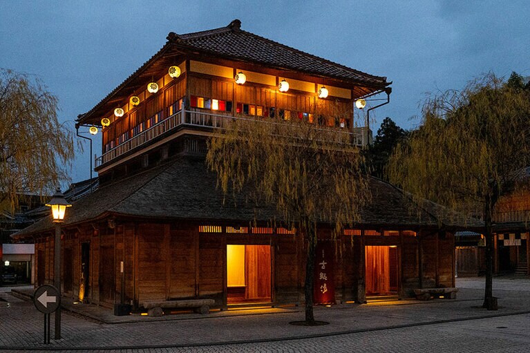 こけら葺きの屋根と2階の窓の意匠が印象的な「古総湯」の外観。