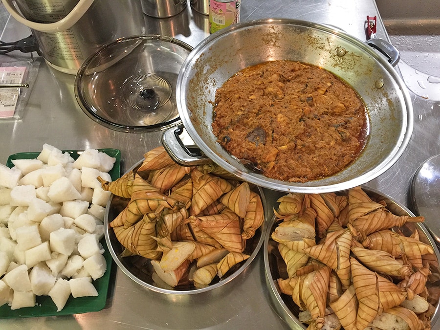 マレーシア人の手料理のチキンルンダン(シルバーの鍋に入っているもの)。ほろほろに肉が崩れるまで煮こまれていた。ちまきに似たご飯クトゥパと一緒に食べた。