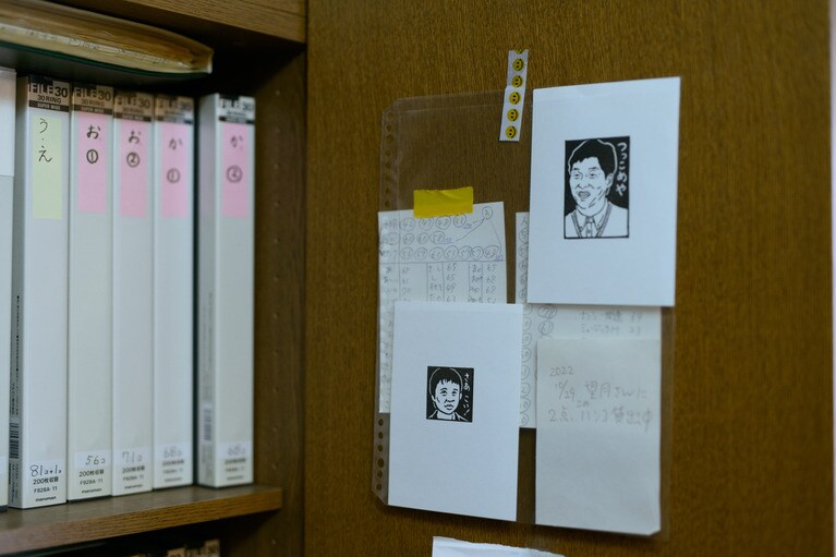 ナンシーさんの消しゴム版画はあいうえお順でファイリングされている。扉に貼られているのは明石家さんま（右）と猿岩石時代の有吉弘行（左）。
