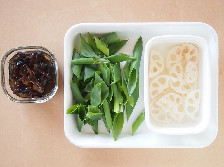 (1) 木耳は水にさらしてもどします。レンコンは皮をむいて、1cm厚さの半月切りにします。長ネギは斜めに切ります。