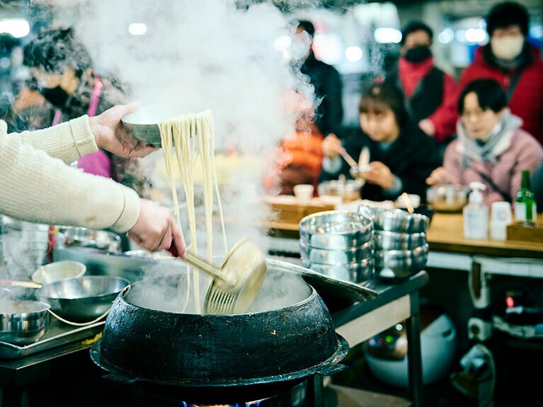 新館地下1階にある店内では安東の方言で手打ち麵を意味するソングッシが絶え間なく茹でられる。毎日仕込まれる小麦粉60％に大豆の粉40％を配合した麵と、大豆の甘味が染み出したスープにニンニクとヤンニョンを入れて食す。／安東チッ（アンドッチッ／안동집）