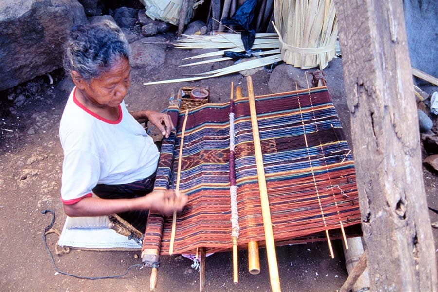 糸を紡ぎ、ヤシの葉を用いた “括り染め”、そして織りまで、すべて昔と変わらぬ技法が守り続けられているラマレラ村のイカットづくり(写真提供：江上幹幸)。