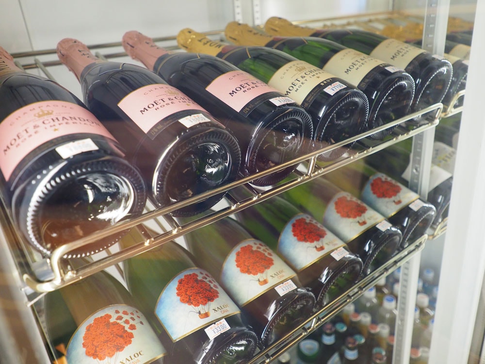 フロント横のワインセラーに、値札のついたワインやシャンパンが置かれている。ここから好きなボトルを選ぼう。