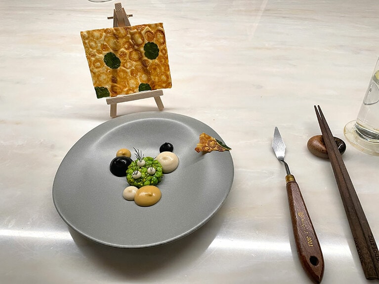 こちらのメニューは、「《畫家》The Artist」。野菜のクッキーをキャンバスに見立て、カボチャや黒ニンニクなどで模様が描かれています。