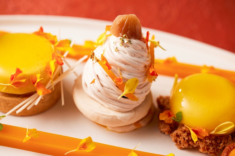 スイーツメニューより、「栗とパッションフルーツのモンブラン」（写真中央）。ラム酒の香りをまとったマロンクリームに、パッションフルーツの酸味を重ね、栗と花々を飾ったモンブラン。
