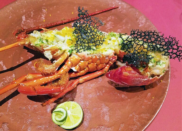 徳島県南部にある椿町で獲れた新鮮な伊勢海老のグリル。春菊を使ったソースと添えられたイカスミのチュイルダンテルがアクセントに。徳島のすだちをたっぷりかけて、驚くほどプリっとした身の弾力を堪能して。