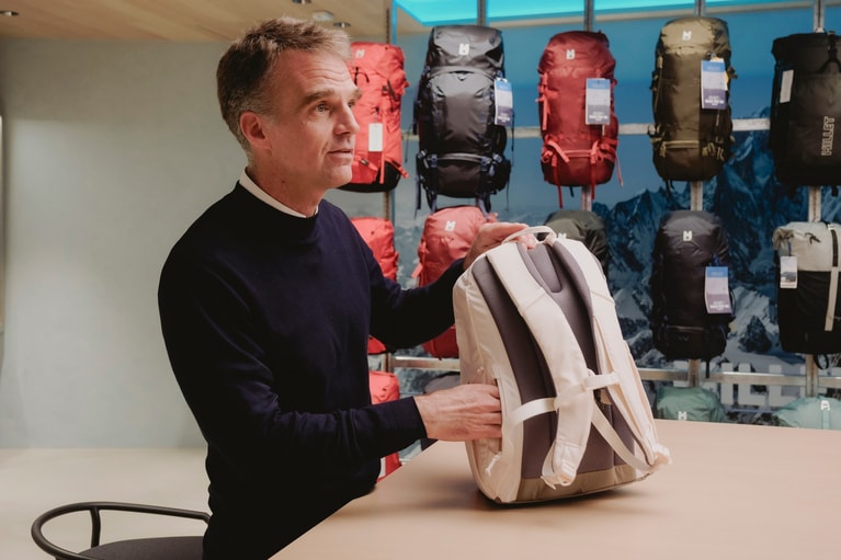 スイウの背負ったままアクセスできる背面ポケットについて説明するロマン氏。