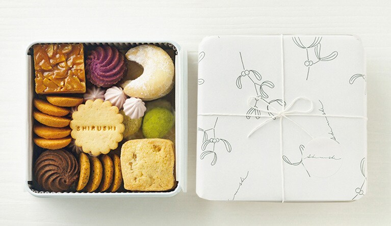添加物を極力使わず、素材の味を生かした焼き菓子を、四季ごとに変わる包装紙に包んで。「ごあいさつの shirushi缶」31個入り 3,000円／菓子屋 shirushi