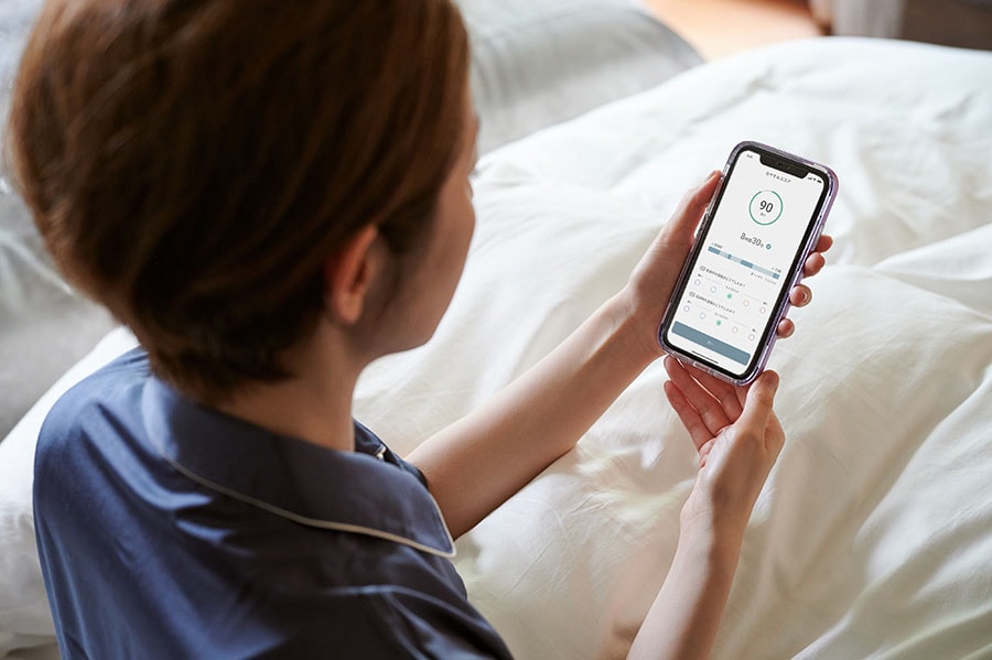 起床後はスマホアプリで就寝中や起床時の温度を主観でフィードバック。睡眠の質を点数化したおやすみスコアや電気代などを見える化して生活に役立てることもできる。