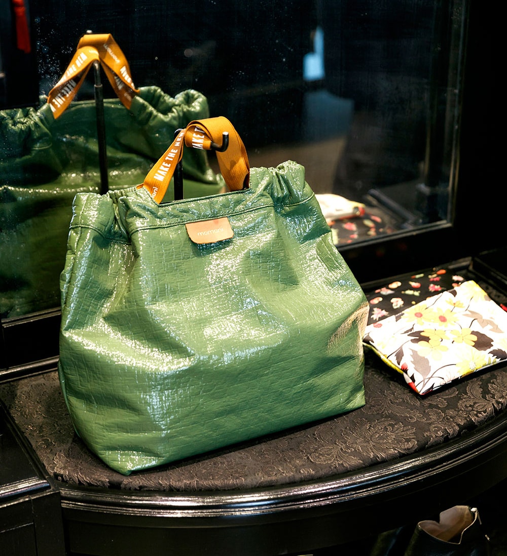 オリーブグリーンのバッグ 189ユーロ、ショルダーバッグにもなるエコレザーのオリジナル柄ポーチ 118ユーロ。