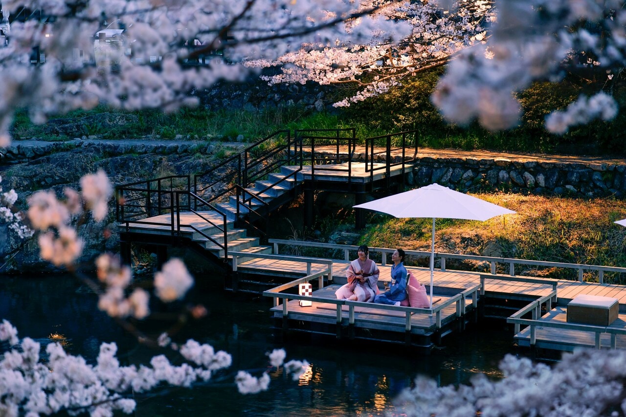 夕食の前には、川床テラスの特等席で桜を鑑賞。ふぐの生ハム、香煎揚げ、雲丹とクリームチーズの桜餅という3種のつまみが日本酒とともに提供される。