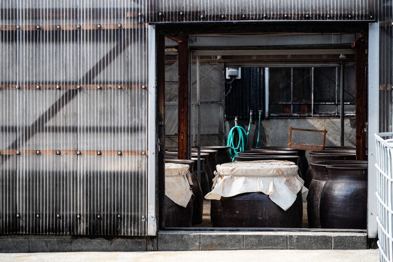 100年以上前に造られた大甕が並ぶ酢蔵。