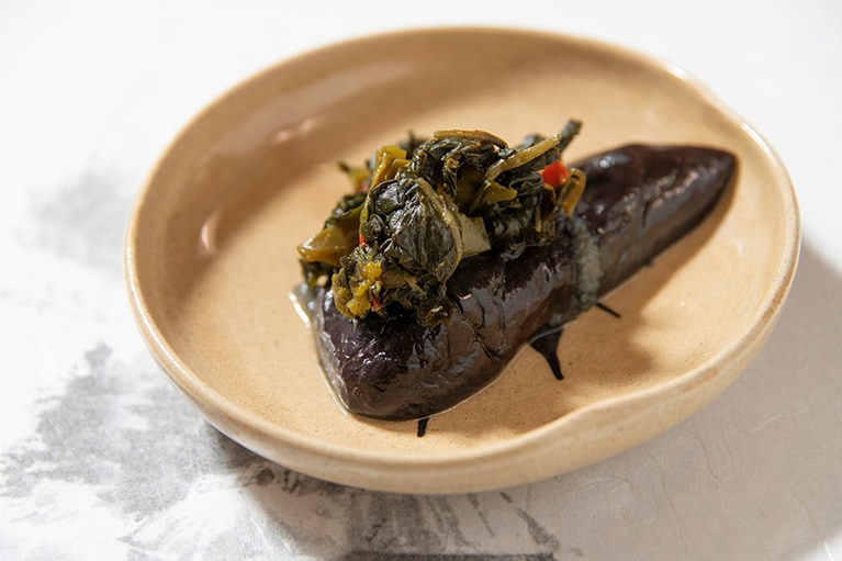 「茄子の煮物とピーマンの葉のみそ炒め」。この地域のご家庭の定番メニューで、食材を余すことなく大切に使い切る文化が受け継がれています。