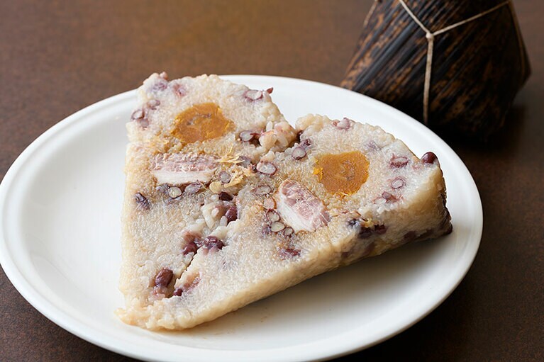 半分に切ってみると塩卵に豚肉と貝柱がごろり。お土産にも最適な南粤ちまき 1,000円。