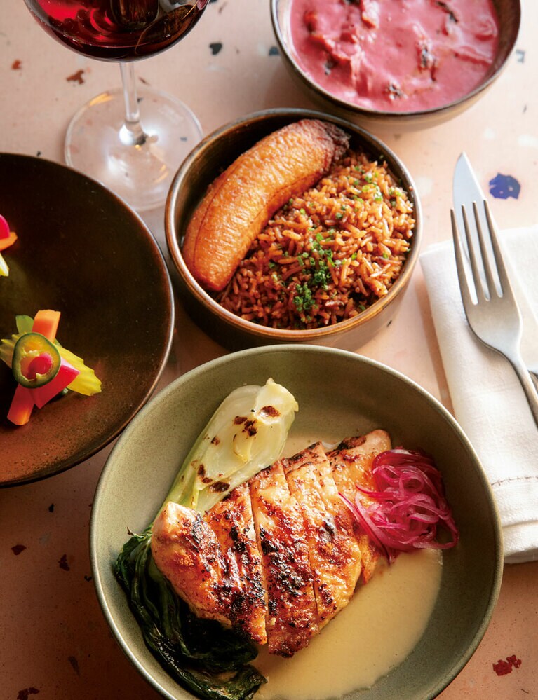 手前はメインの一つ“Yassa”。ホロホロ鳥の炭火焼にピーナッツベースのスパイシーソース。各メインディッシュには自家製ピクルスのほかライスとキャラメリゼしたプランテンがつく。