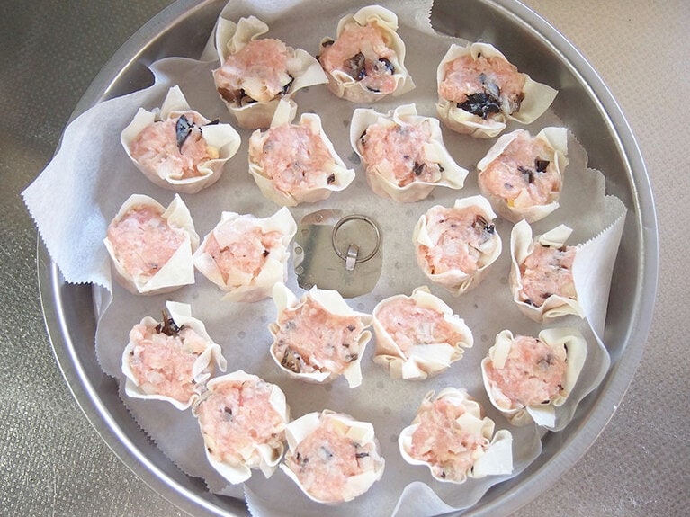 (5) 蒸し器にクッキングシートをセットし、包んだ焼売を並べます。隣同士、隙間を開けるようにして並べましょう。