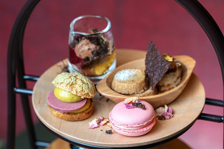 アフタヌーンティー上段のイメージ。トップから、チョコレートパフェ、シュトーレン（風戸スタイル）、シナモン＆クルミのクッキー、苺のマカロン、ピスタチオのシュークリーム。