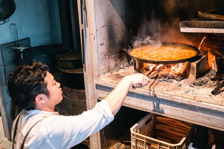 パエリアの火加減を調整する田村さん。（撮影：石川博也）