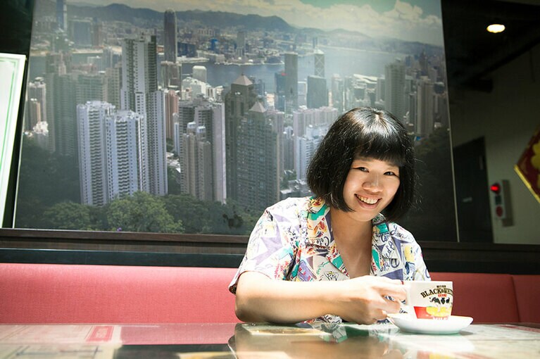 少しでも時間ができると、香港に足を運んでいる伊藤さん。香港の摩天楼を背ににっこり。「香港 贊記茶餐廳」にて。