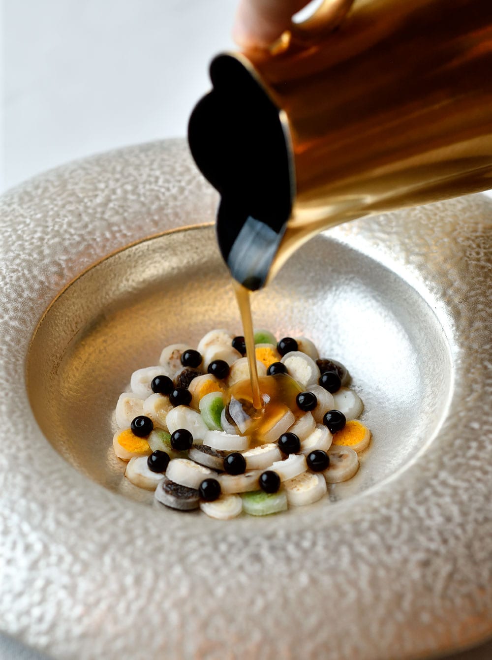 カラフルな具材をダイコンで巻き、バルサミコ酢のキャビアをちらして酸辣湯を再構築。川江月の美しい一皿。