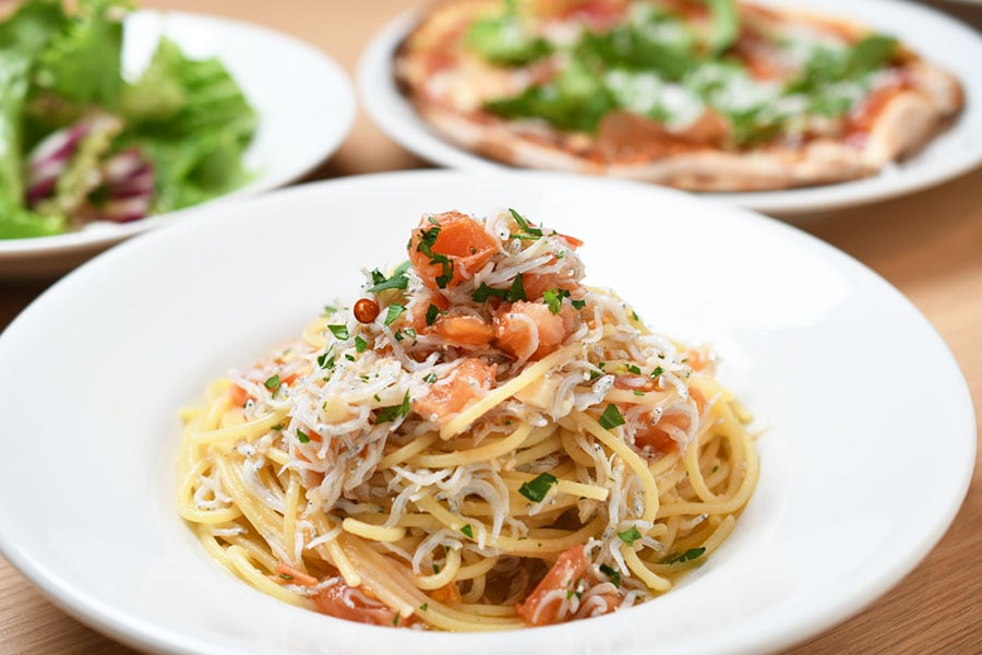 新鮮な食材をたっぷり使用した「安芸産シラスとフレッシュトマトのスパゲッティ」や「ルッコラと生ハムのピッツァ」は人気のメニュー。
