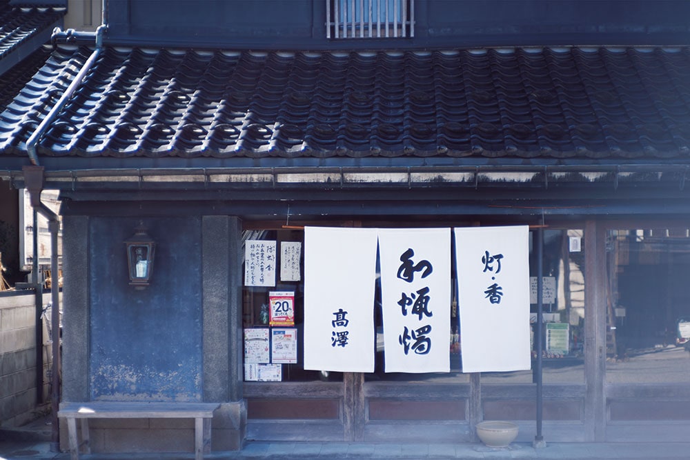 筆文字が老舗の風格を感じさせる暖簾。七尾では江戸時代の1650年頃、蠟燭座といわれるろうそくの販売組合のようなものがあり、明治にかけて盛んに作られていた。