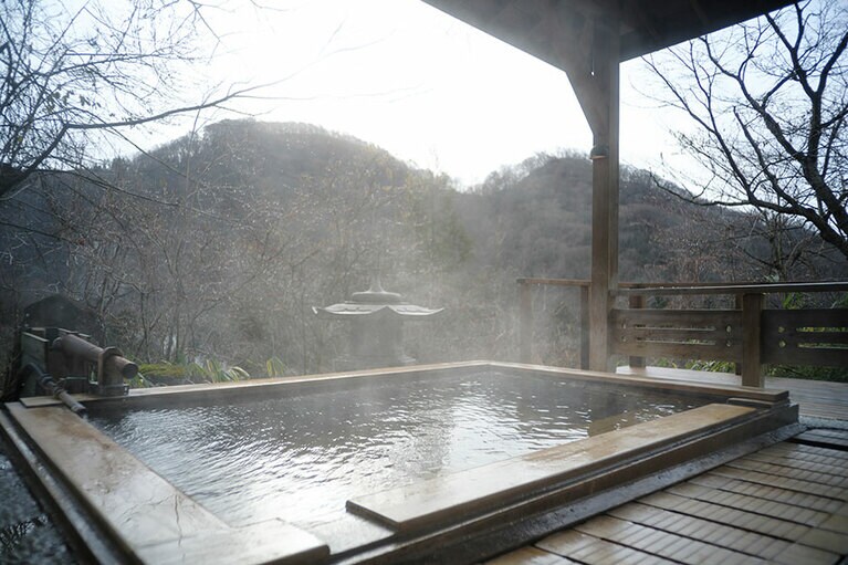 露天風呂付き特別室『松島』は1泊2食付き(2人利用)1人 44,000円～(休前日 47,300円～)※入湯税別。広々とした露天の檜風呂は源泉かけ流しで、山の景色も見晴らせます。