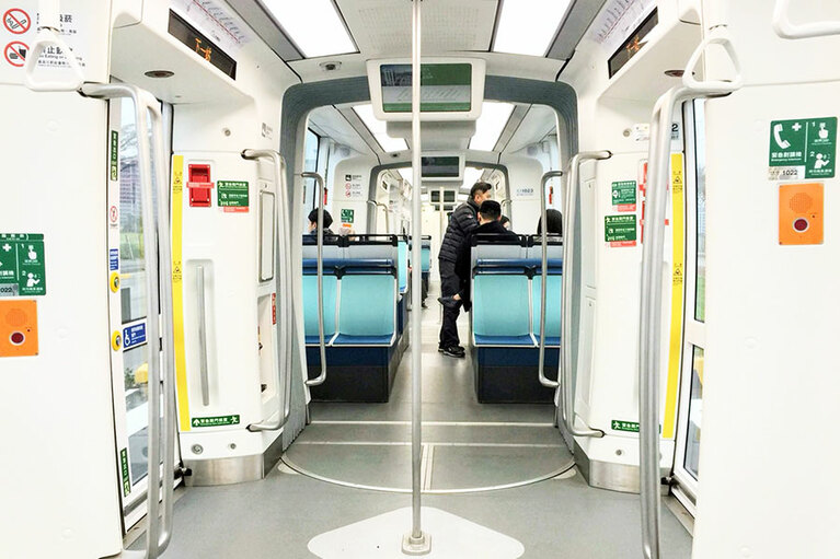 車内はバリアフリー、白い壁に明るい車内が印象的。