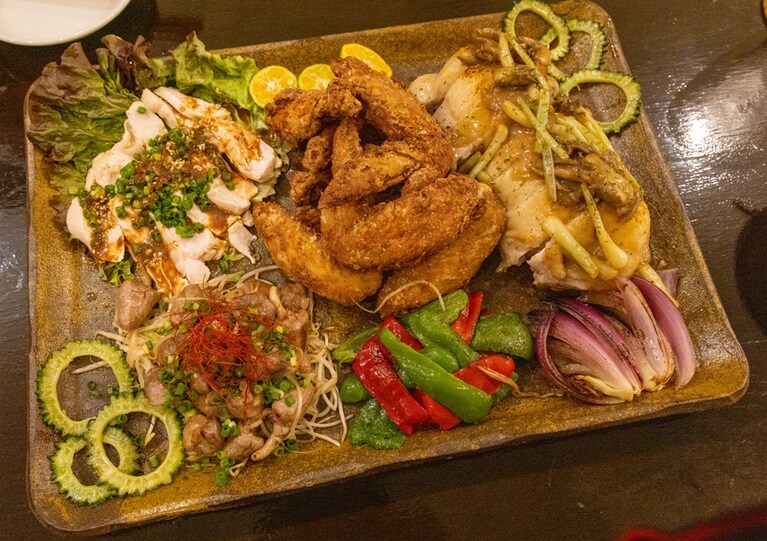 久米島赤鶏牧場の赤鶏を使った料理の豪華な盛り合わせ。