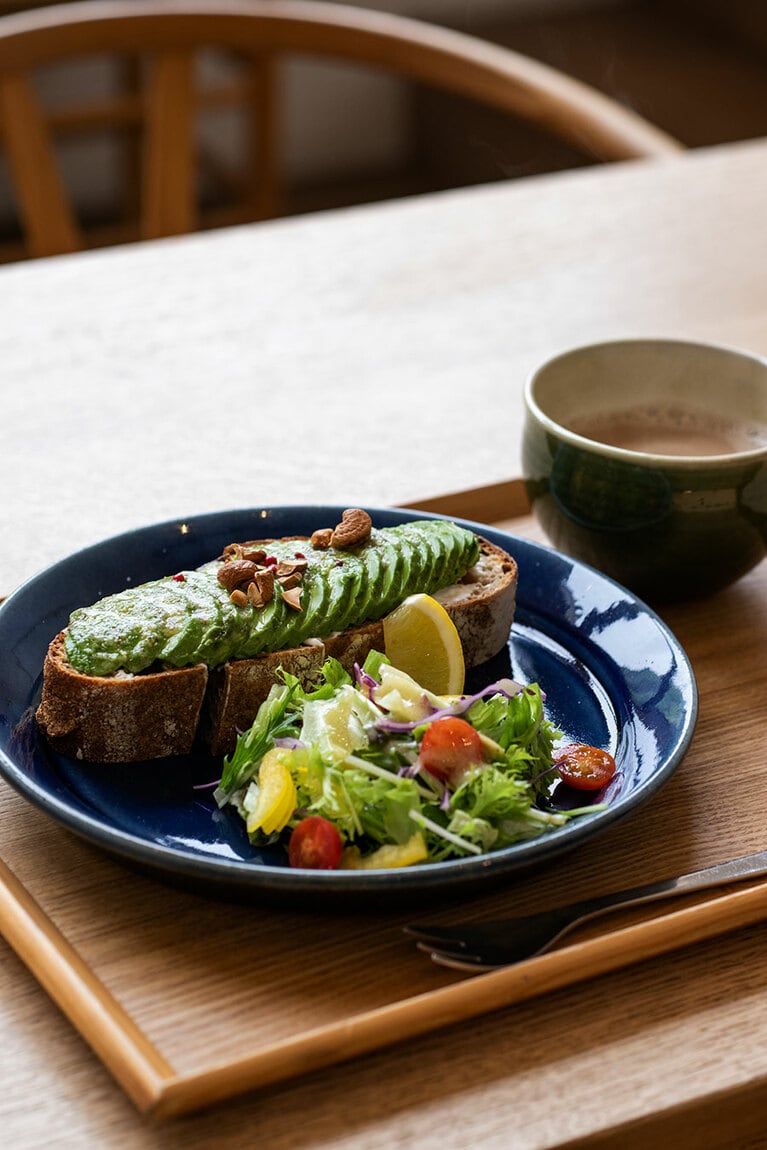 「ル コションドール 出西」でほっとひと息。“アボカドとリコッタチーズのオープンサンド” 1,050円、カフェオレ 540円。